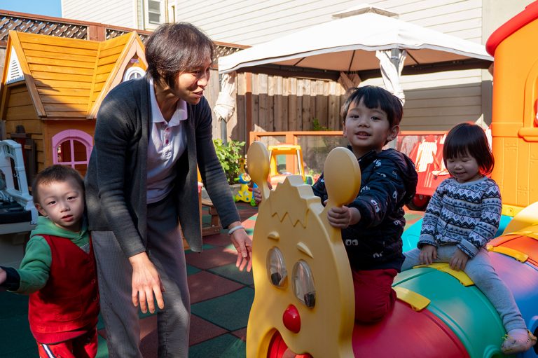 Un profesor interactuando con los niños en el patio de recreo